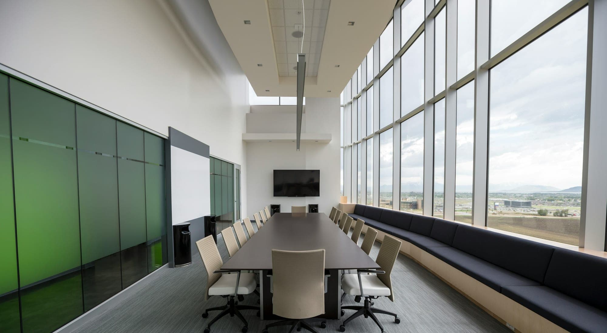 A quiet meeting room with a long table and full-height windows