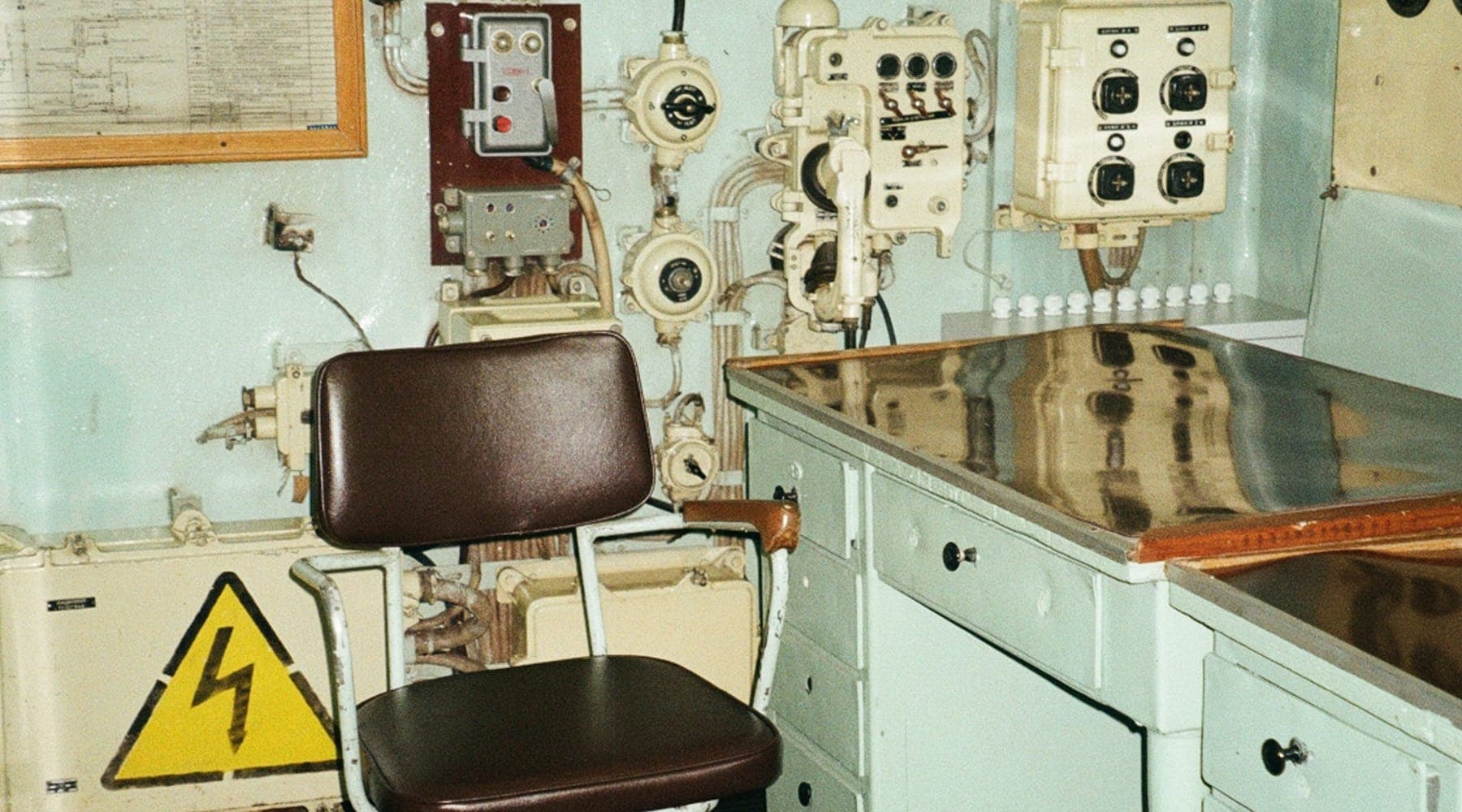 A control room lined with electrical panels, switches and instrument gauges