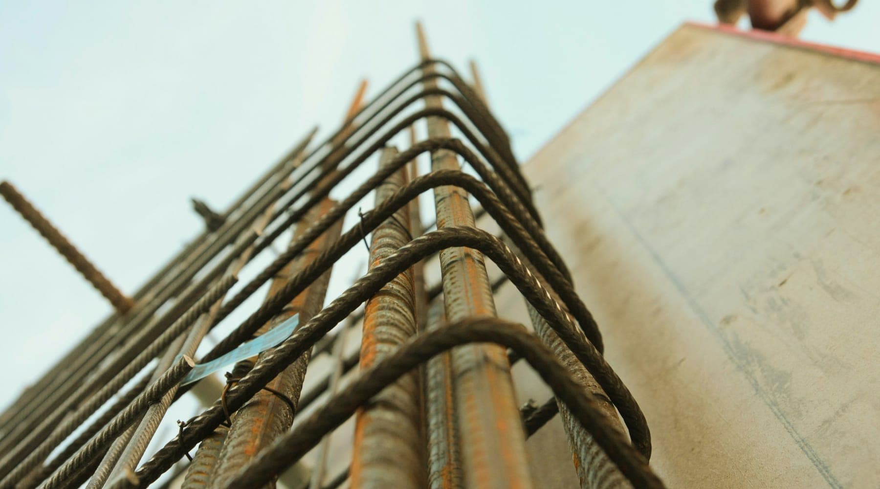 A reinforcement cage rising against the sky beside a poured concrete core